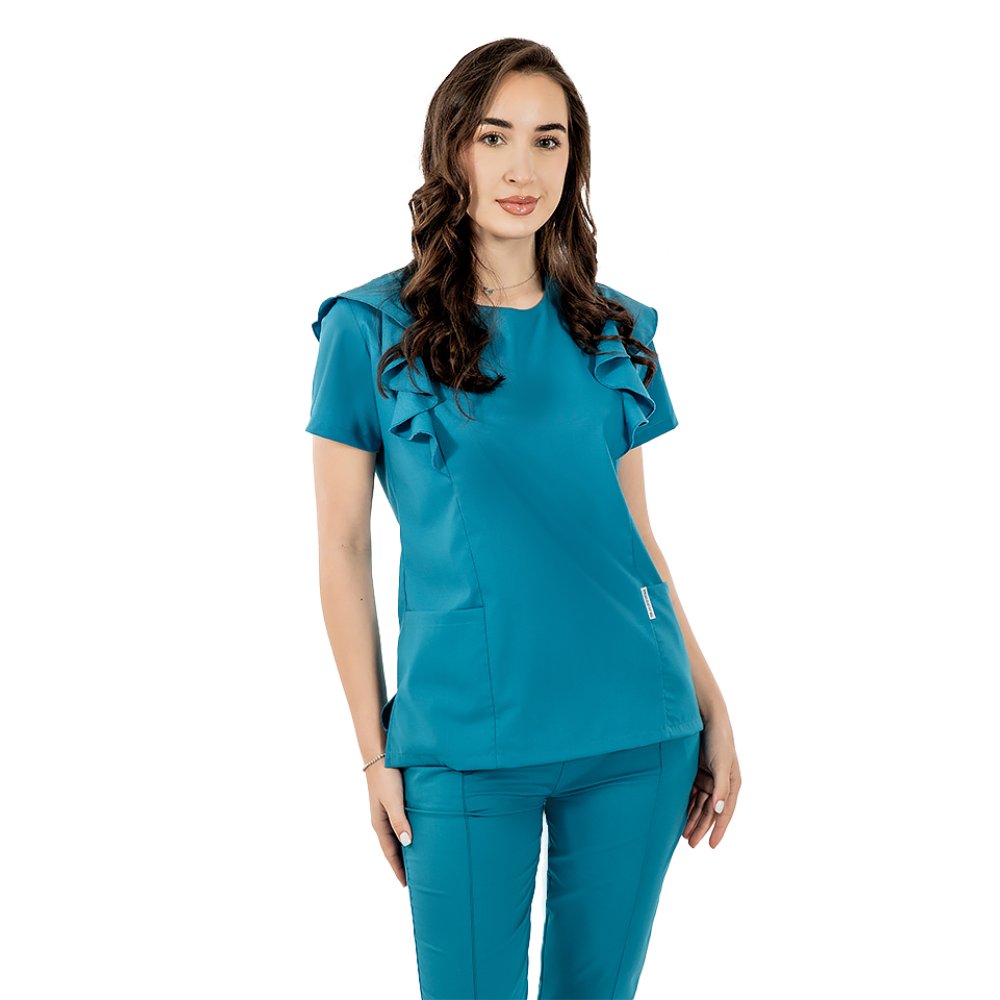 Kombinezon medyczny Cristina, rozciągliwy, w kolorze aqua, z falbaniastą bluzką oraz ściągaczami i elastycznymi spodniami Kombinezon medyczny Cristina, rozciągliwy, w kolorze aqua, z falbaniastą bluzką oraz ściągaczami i elastycznymi spodniami
