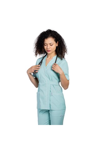 Miętowy, elastyczny kombinezon medyczny, składający się z bluzki typu kimono z białą lamówką i spodniami typu jogger
