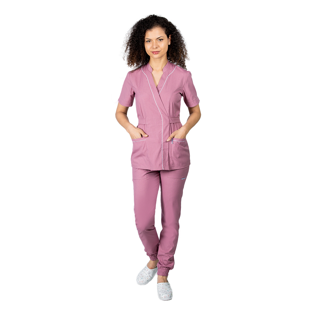 Kombinezon medyczny ze stretchem w kolorze pudrowego różu, składający się z kimonowej bluzki z białą lamówką i spodniami typu jogger